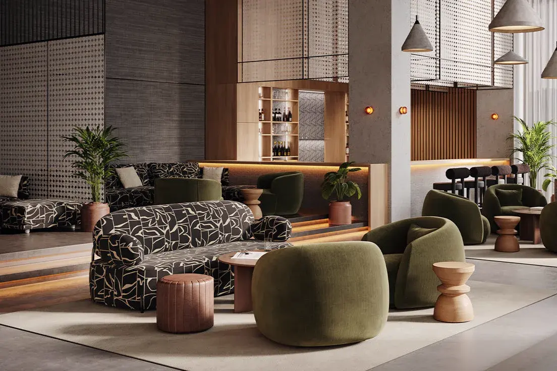 Hotel lounge with patterned upholstery, velvet armchairs and a backlit bar